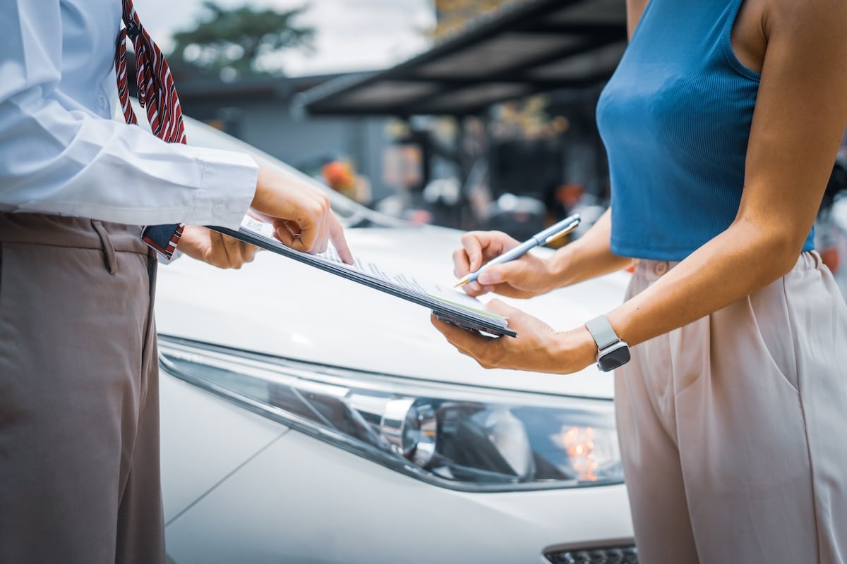 Woman signing a document with an attorney following a personal injury